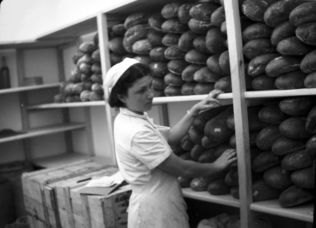 Woman stocking shelves with bread